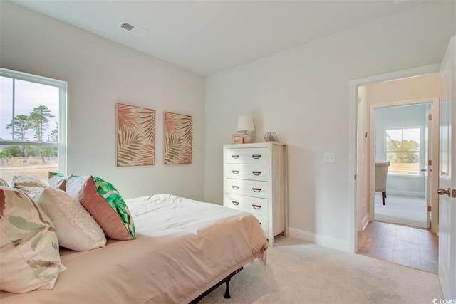 bedroom featuring light colored carpet and baseboards