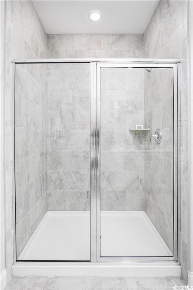 bathroom featuring a shower with shower door