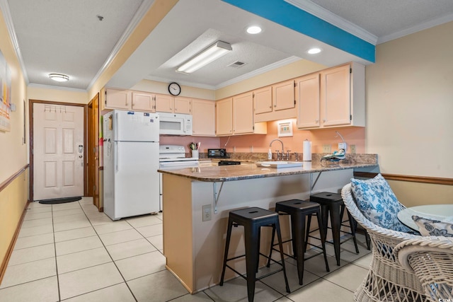 kitchen featuring ornamental molding, dark stone counters, light tile patterned floors, sink, and white appliances