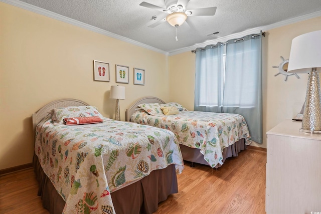 bedroom with light hardwood / wood-style floors, ceiling fan, a textured ceiling, and ornamental molding