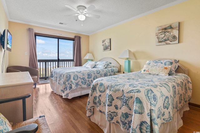 bedroom featuring dark hardwood / wood-style flooring, a textured ceiling, ceiling fan, and access to exterior