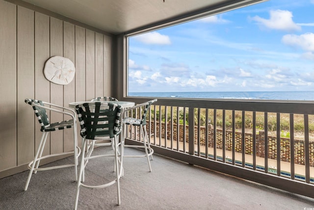 balcony featuring a water view and a beach view