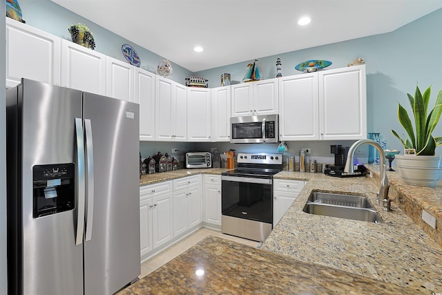 kitchen with white cabinetry, appliances with stainless steel finishes, sink, and light stone counters