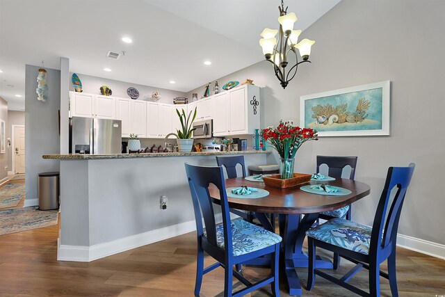 dining area featuring dark wood-type flooring and a chandelier