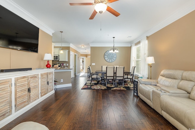 living room featuring dark wood-type flooring, ceiling fan with notable chandelier, and ornamental molding