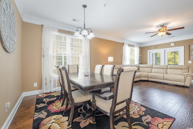 dining space with dark wood-type flooring, ceiling fan with notable chandelier, french doors, and crown molding