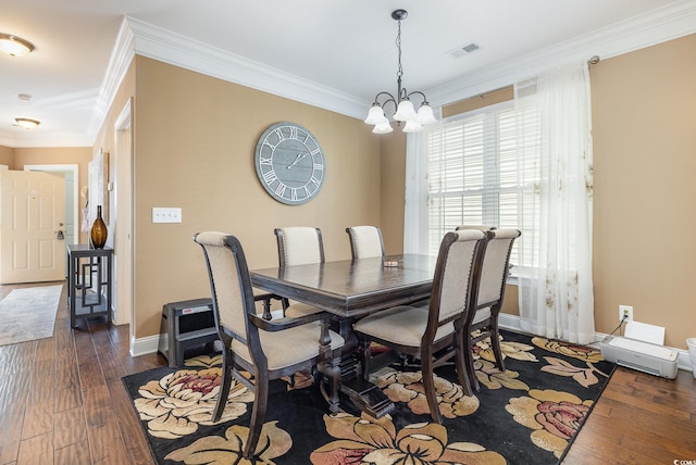 dining room with dark wood-type flooring, an inviting chandelier, and crown molding