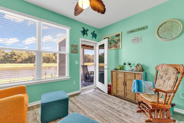 sitting room with hardwood / wood-style floors and ceiling fan