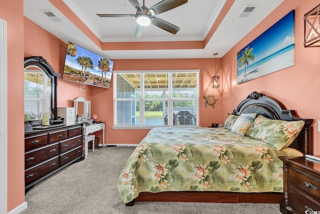 bedroom featuring multiple windows, light carpet, ceiling fan, and a tray ceiling