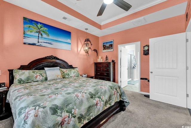 carpeted bedroom with ornamental molding, ceiling fan, and a raised ceiling