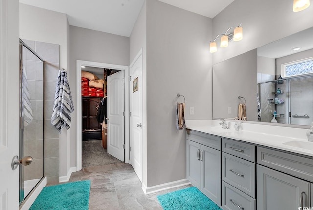 bathroom with a shower with shower door and vanity