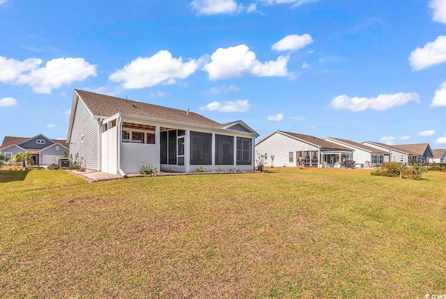 rear view of property featuring a sunroom and a yard