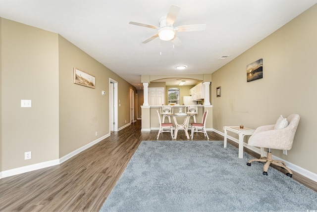 living area with dark hardwood / wood-style floors and ceiling fan