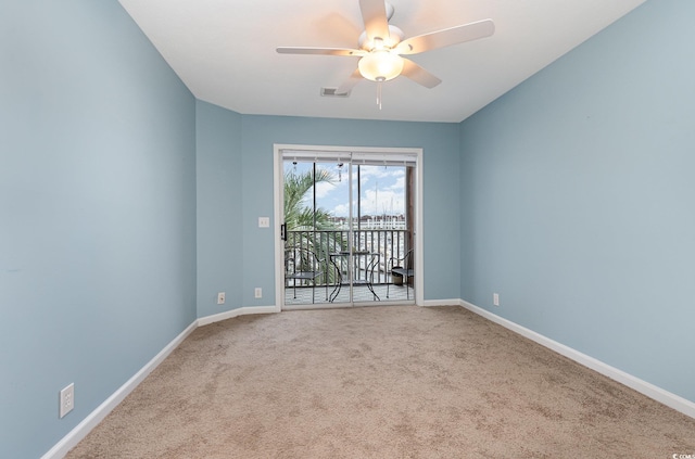 empty room featuring ceiling fan and light carpet