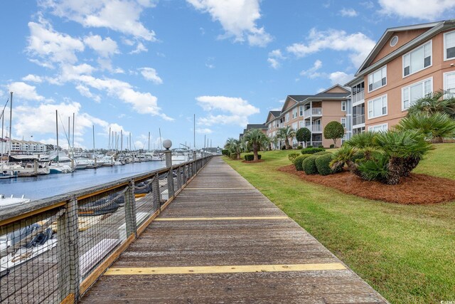 dock area with a water view and a yard