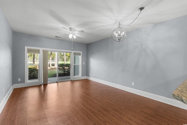 empty room featuring wood-type flooring and ceiling fan with notable chandelier