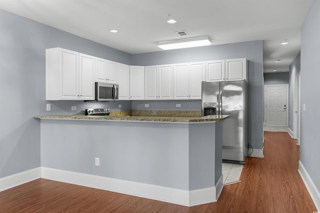 kitchen featuring white cabinetry, kitchen peninsula, stainless steel appliances, and light hardwood / wood-style floors