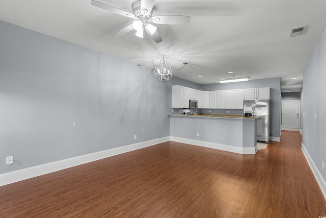 kitchen featuring ceiling fan with notable chandelier, dark wood-type flooring, kitchen peninsula, white cabinetry, and appliances with stainless steel finishes