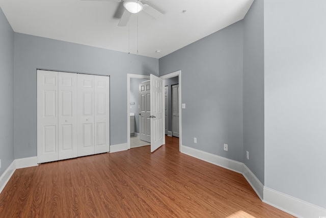 unfurnished bedroom featuring hardwood / wood-style floors, ceiling fan, and a closet