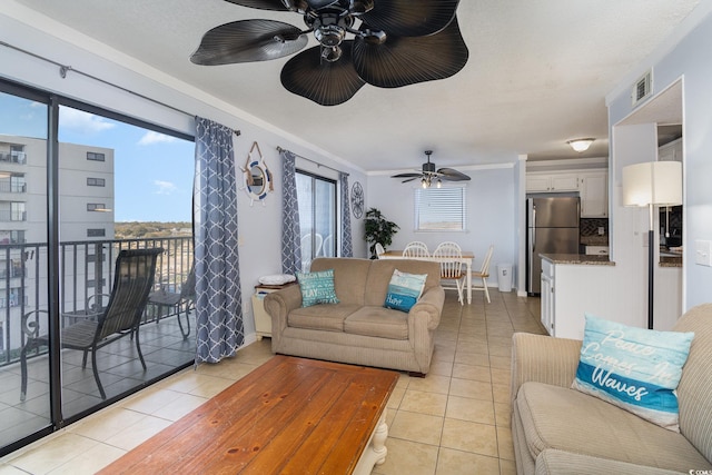 living room featuring ceiling fan, light tile patterned floors, and ornamental molding