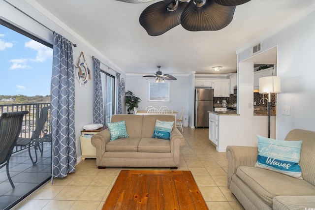 living room with light tile patterned flooring, ceiling fan, sink, and a healthy amount of sunlight