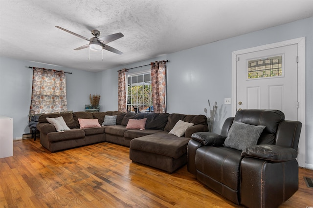 living room featuring a textured ceiling, hardwood / wood-style flooring, and ceiling fan