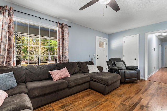 living room with ceiling fan, wood-type flooring, and a textured ceiling