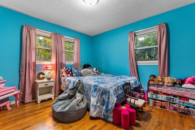 bedroom featuring light wood-type flooring and a textured ceiling