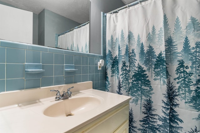 bathroom featuring tile walls, walk in shower, vanity, and a textured ceiling