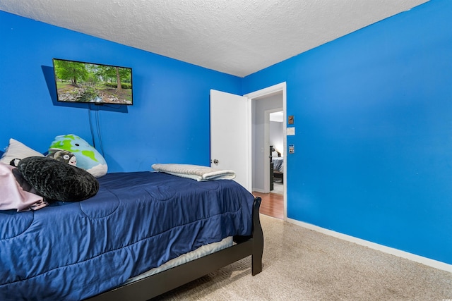 bedroom featuring a textured ceiling and carpet