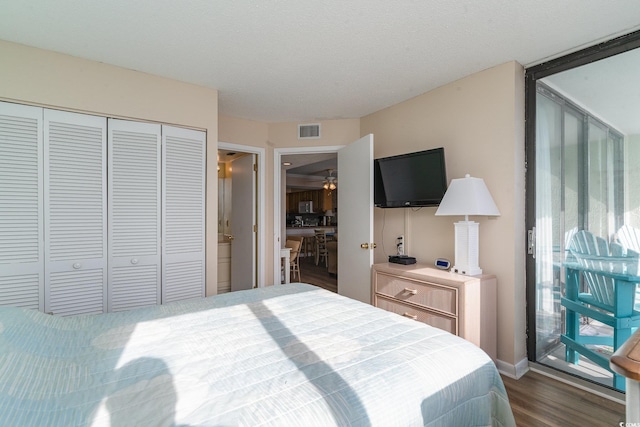 bedroom with dark wood-type flooring, a textured ceiling, and a closet