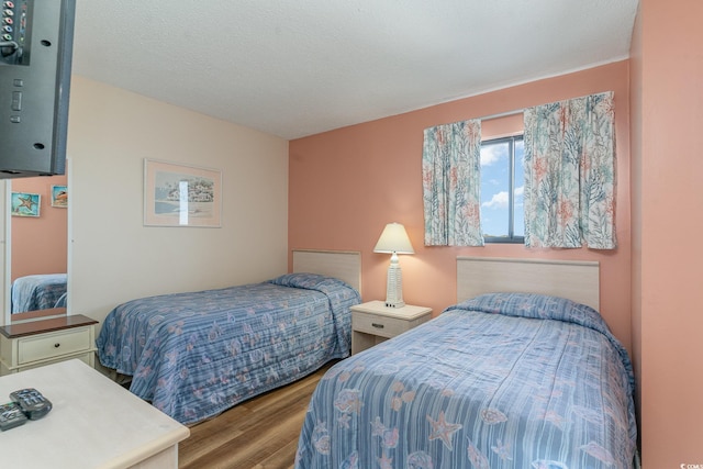 bedroom featuring hardwood / wood-style floors and a textured ceiling