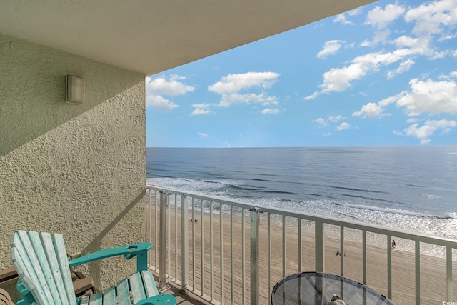 balcony with a water view and a beach view