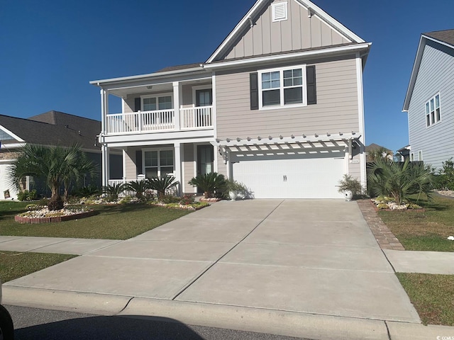 view of front facade with a balcony, a front lawn, and a garage