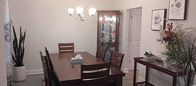 dining room featuring dark hardwood / wood-style flooring and an inviting chandelier