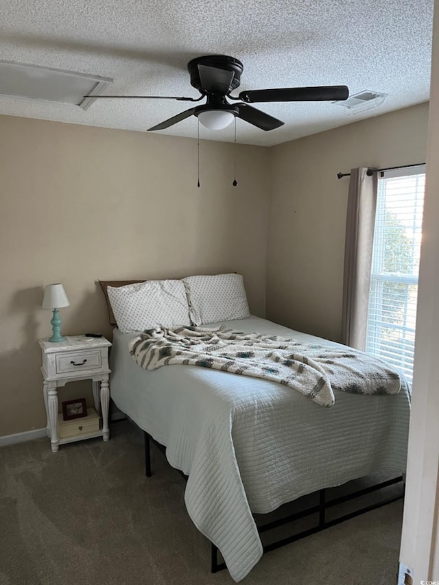 bedroom with a textured ceiling, ceiling fan, and dark carpet