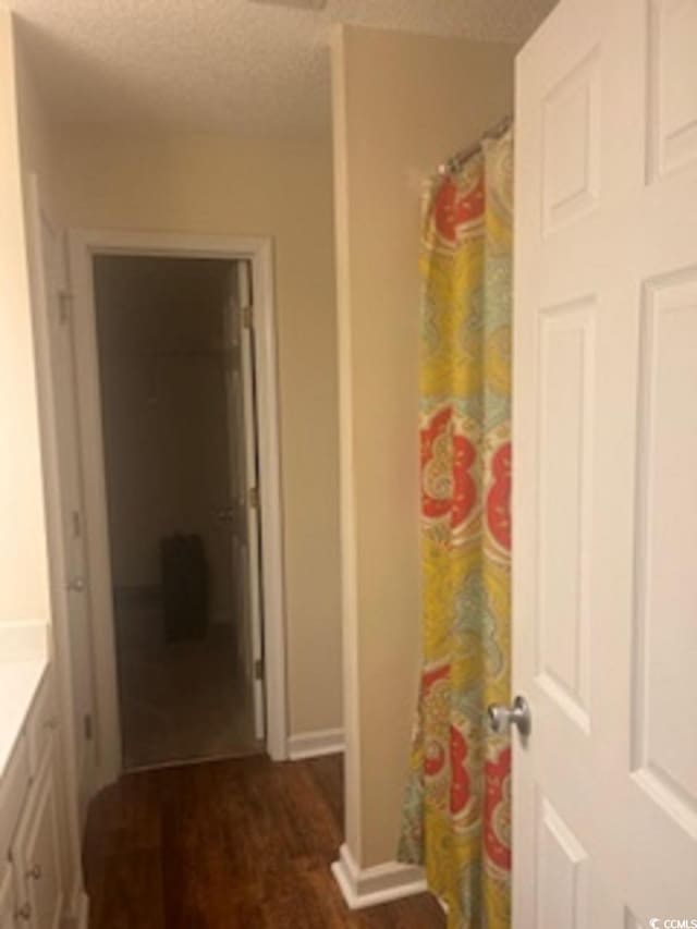 bathroom with wood-type flooring, vanity, and a textured ceiling