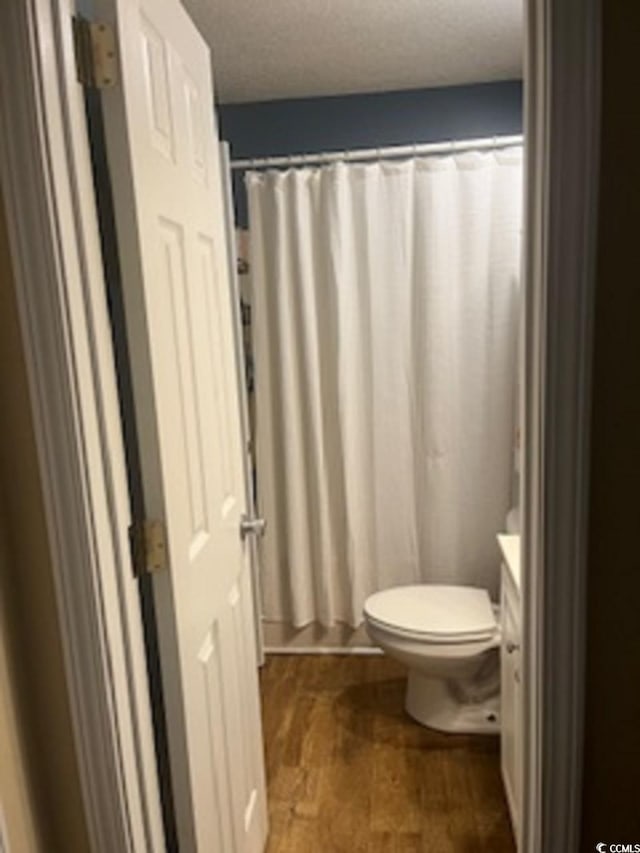 bathroom featuring a shower with curtain, vanity, and toilet