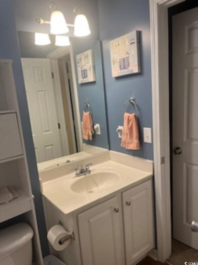 bathroom featuring a chandelier, vanity, and toilet