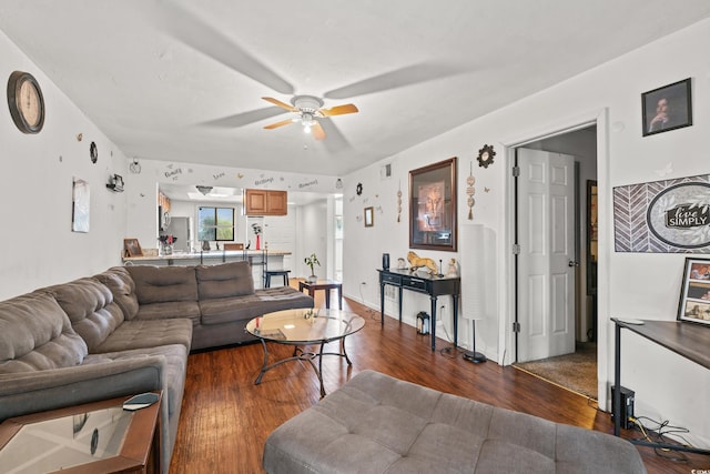 living room with ceiling fan and dark wood-type flooring