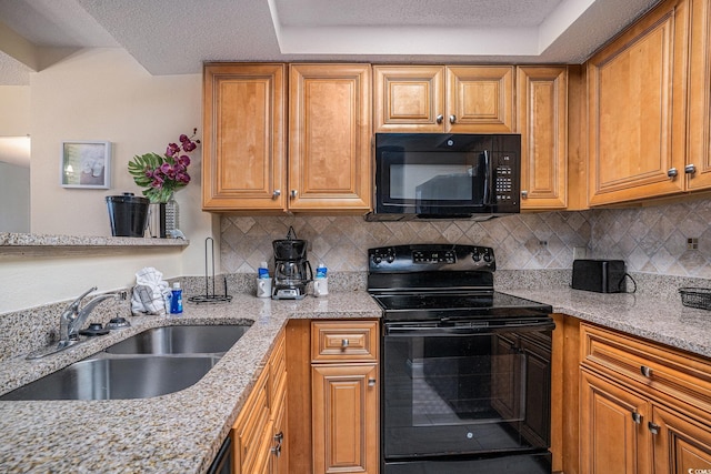 5308 N Ocean Blvd Unit 1014, Myrtle Beach, SC 29577 - kitchen featuring black appliances, a sink, light stone countertops, brown cabinets, and a textured ceiling