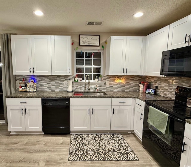 kitchen with white cabinets, a textured ceiling, sink, and black appliances