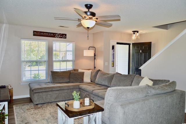 living room with a textured ceiling, hardwood / wood-style floors, and ceiling fan