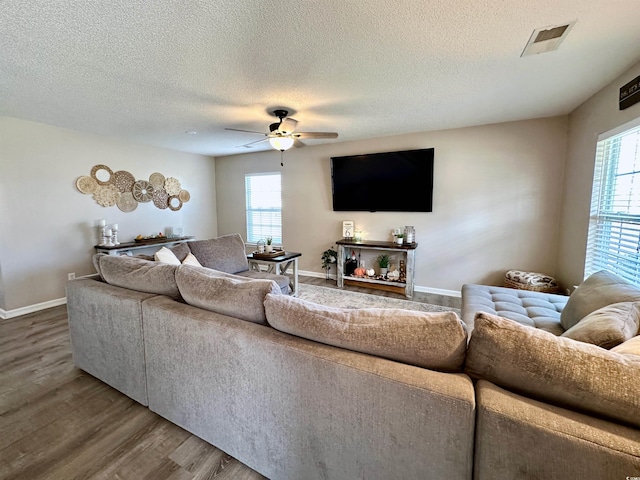 living room with ceiling fan, a healthy amount of sunlight, a textured ceiling, and hardwood / wood-style floors