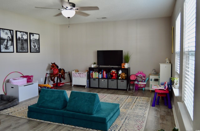 playroom with ceiling fan and wood-type flooring