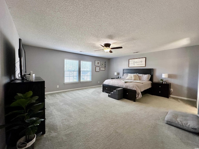 bedroom featuring a textured ceiling, ceiling fan, and light colored carpet