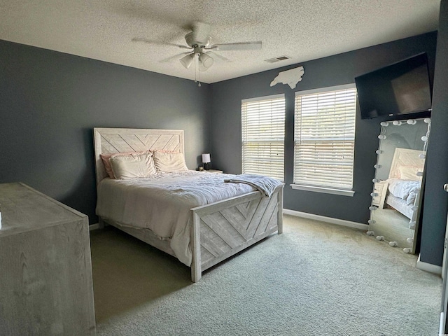 carpeted bedroom with a textured ceiling and ceiling fan