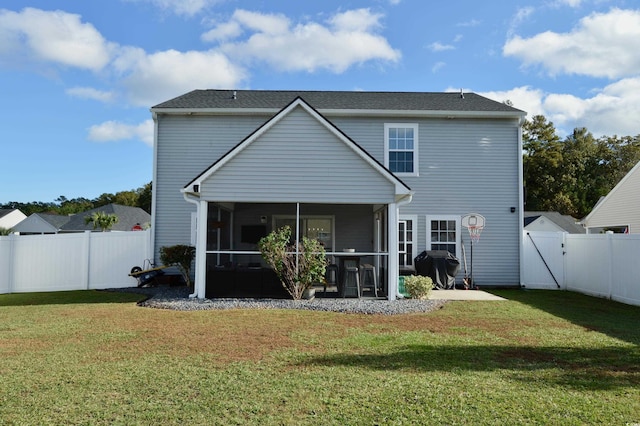 rear view of house featuring a yard and a sunroom