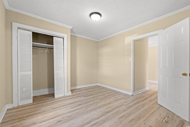 unfurnished bedroom with a textured ceiling, light wood-type flooring, and crown molding