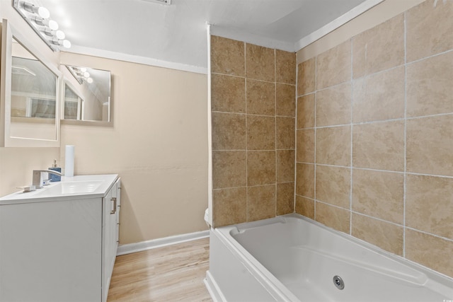 bathroom featuring vanity, wood-type flooring, and tiled shower / bath